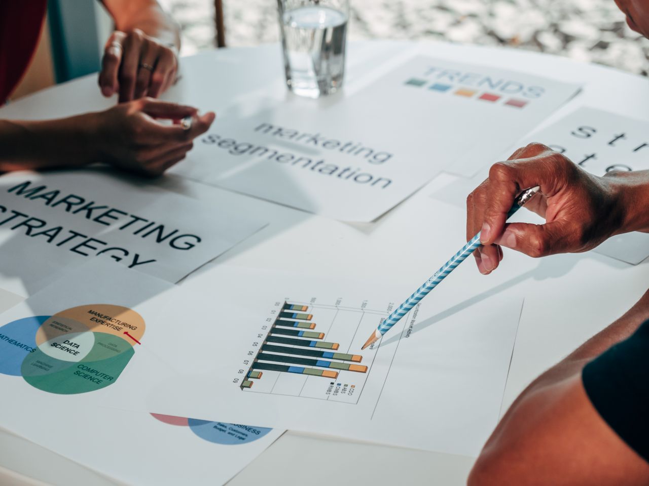 Team working on marketing strategy using data charts and papers in an office meeting.